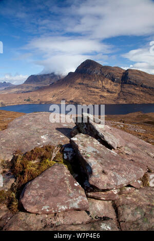 Vista sul Loch Lurgainn a Cul Beag e Cul Mor, con rocce in primo piano, Ben Mor Coigach Scottish Wildlife Trust Reserve, Coigach, Scozia, marzo 2012. Foto Stock