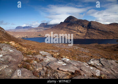 Vista sul Loch Lurgainn a Cul Beag e Cul Mor, con rocce in primo piano, Ben Mor Coigach Scottish Wildlife Trust Reserve, Coigach, Scozia, marzo 2012. Foto Stock