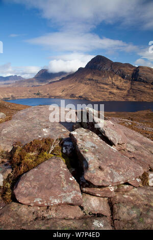 Vista sul Loch Lurgainn a Cul Beag e Cul Mor, con rocce in primo piano, Ben Mor Coigach Scottish Wildlife Trust Reserve, Coigach, Scozia, marzo 2012. Foto Stock