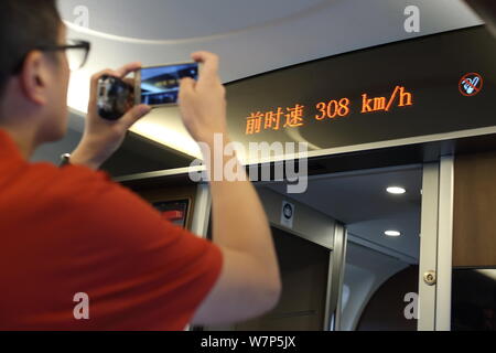 Un passeggero prende le foto di una schermata di visualizzazione della corrente velocità del treno in un 'Fuxing' alta velocità del treno bullet Beijing-Shanghai sulla rete ferroviaria ad alta velocità l Foto Stock