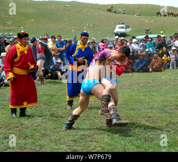 Lottatori mongola ad una competizione di wrestling durante un Naadam in un piccolo villaggio Foto Stock