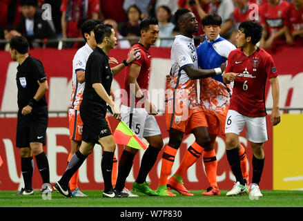 Tomoaki Makino del Giappone del Urawa Red Diamonds liti con i giocatori della Corea del Sud, Jeju uniti nella loro seconda tornata del 16 corrispondano durante l'AFC Champ Foto Stock