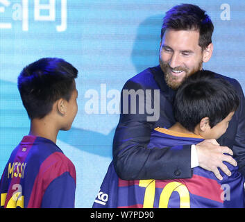Attaccante argentino Lionel Messi del FC Barcelona, destra, interagisce con i giovani fan cinesi durante una conferenza stampa per il Provveditore esperienza nel Parco Foto Stock