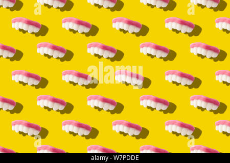 Fotografia collage di gummy i denti di latte o jelly caramelle in grassetto su sfondo giallo superiore piatta vista isometrica laici seamless pattern.divertente per bambini trattare Foto Stock