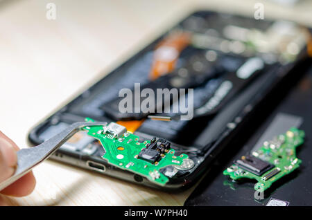 Modificare il pannello di chip Smartphone caricabatterie da riparare sul tavolo. Foto Stock