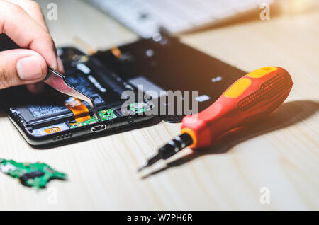 Modificare il pannello di chip Smartphone caricabatterie da riparare sul tavolo. Foto Stock