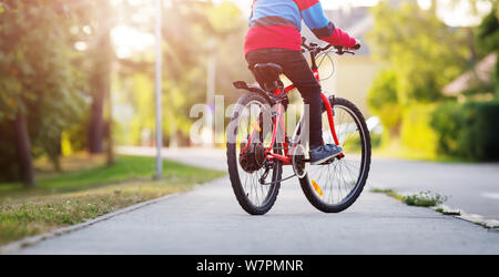 Bambino su una bicicletta di sera Foto Stock