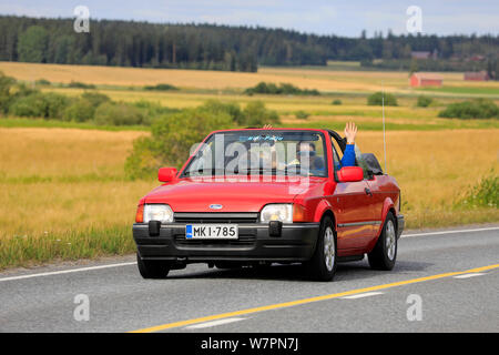 Vaulammi, Finlandia. Il 3 agosto 2019. Famiglia Sorridendo e agitando su degli anni novanta red Ford Escort cabriolet su Maisemaruise 2019 auto crociera. Credito: Taina Sohlman Foto Stock