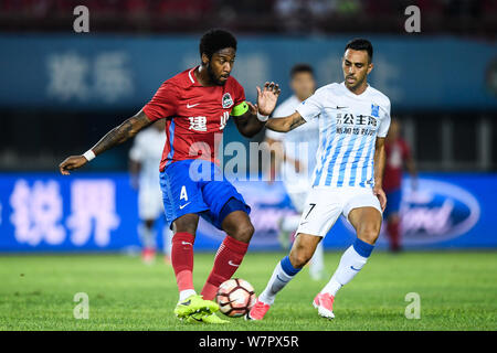 Il calcio danese player Edigeison Gomes, sinistra, di Henan Jianye calci la palla per effettuare un sorpasso contro israeliani giocatore di calcio Eran Zahavi di Guangzhou R Foto Stock