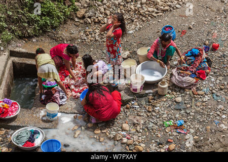 Le donne il lavaggio di indumenti e biancheria fuori su una strada di Kathmandu Foto Stock