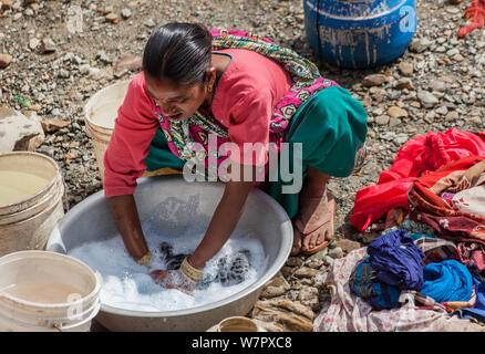 La donna il lavaggio di indumenti e biancheria fuori su una strada di Kathmandu Foto Stock