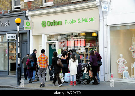 Le persone che cercano nella finestra di una carità Oxfam shop Marylebone High Street, quartiere londinese di Westminster, Inghilterra UK, Marzo 2009 Foto Stock