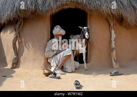 Custode di capra con il bambino e la capra domestica (Capra aegagrus hircus) deserto di Thar, Rajasthan, India Foto Stock