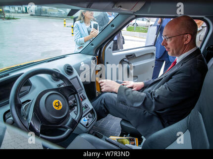 Wittenburg, Germania. 07 Ago, 2019. Pegel cristiana (SPD), l'energia e il ministro dei Trasporti del Land Meclemburgo-Pomerania occidentale, si siede sul sedile del passeggero di un " strada scooter', azionato elettricamente van per Deutsche Post di consegna pacchi personale. Pegel può scoprire più circa l'uso di electromobility presso la Deutsche Post DHL delivery base. Dei 14.300 veicoli operati da Swiss Post in tutta la Germania, circa 9.000 sono alimentati elettricamente i furgoni. In aggiunta alla 'Streetscooter', 3.000 e-bikes sono anche in uso. Credito: Jens Büttner/dpa-Zentralbild/dpa/Alamy Live News Foto Stock