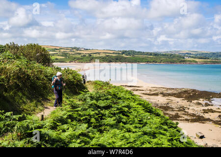 Le donne che camminano escursionismo sul Galles sentiero costiero intorno alla baia di Lligwy, Isola di Anglesey, Galles, Regno Unito, Gran Bretagna Foto Stock