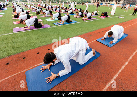 Gli appassionati cinesi vestite di bianco eseguire lo yoga sotto la guida dei maestri yoga indiano Shitanshu Sharma e Jitendra Kumawat per contrassegnare il Inte Foto Stock