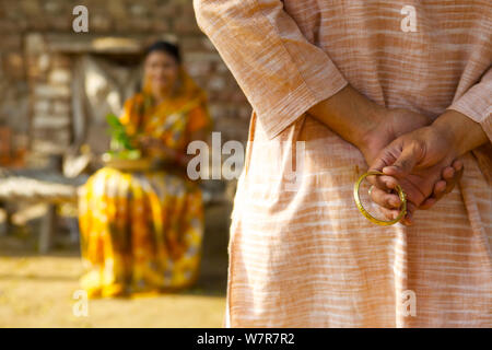 Rural man hiding gift behind back from his wife Stock Photo