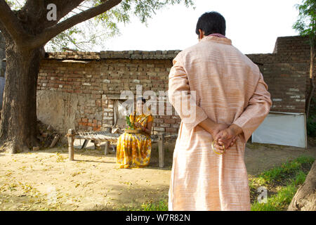 Rural man hiding gift behind back from his wife Stock Photo