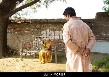 Rural man hiding gift behind back from his wife Stock Photo