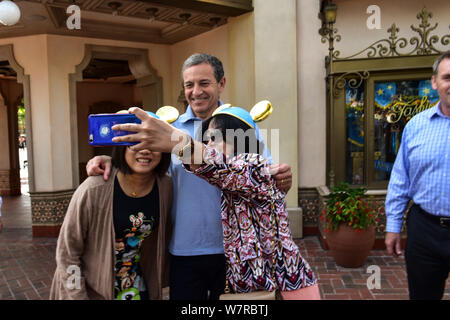 Robert A. Iger (Bob Iger), centro, Presidente e CEO di The Walt Disney Company, pone per le foto con i turisti durante il primo anniversario celebrati Foto Stock
