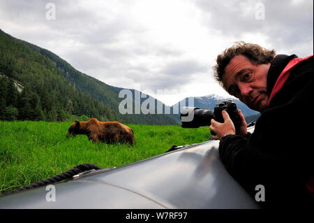 Il fotografo Eric Baccega fotografando un grizzly (Ursus arctos horribilis) da una barca Zodiac, Khutzeymateen Orso grizzly Santuario, British Columbia, Canada, giugno 2013. Foto Stock