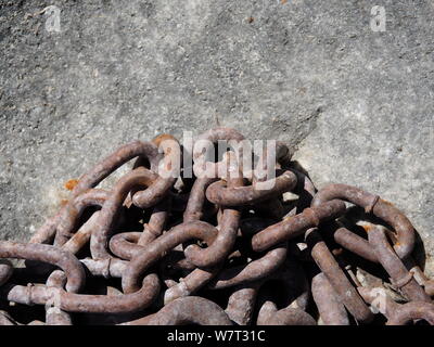 In prossimità di una pila di vecchi catena arrugginito sul rock Foto Stock