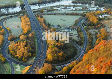 Alba luce su un bosco misto e la strada a doppia carreggiata in autunno. Kinnoull Hill parco boschivo, Perthshire Scozia, novembre 2012. Foto Stock