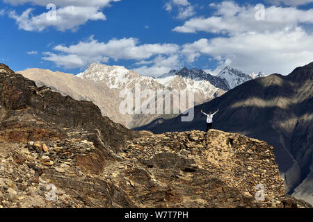 Vista sulla valle di Wakhan nel Pamir mountain, turistico in piedi sulle rovine del Yamchun Fort cercando sul bianco Hindu Kush gamma in Afghanistan, T Foto Stock