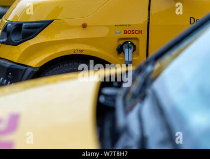 Wittenburg, Germania. 07 Ago, 2019. Un condotto elettricamente parcel transporter 'Streetscooter' è caricata con energia elettrica in corrispondenza di una stazione di ricarica nella base di consegna della Deutsche Post. Dei 14.300 veicoli operati da Swiss Post in tutta la Germania, circa 9.000 sono alimentati elettricamente i furgoni. In aggiunta alla 'Streetscooter', 3.000 e-bikes sono anche in uso. Credito: Jens Büttner/dpa-Zentralbild/ZB/dpa/Alamy Live News Foto Stock