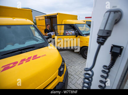 Wittenburg, Germania. 07 Ago, 2019. Un condotto elettricamente parcel transporter 'Streetscooter' è caricata con energia elettrica in corrispondenza di una stazione di ricarica nella base di consegna della Deutsche Post. Dei 14.300 veicoli operati da Swiss Post in tutta la Germania, circa 9.000 sono alimentati elettricamente i furgoni. In aggiunta alla 'Streetscooter', 3.000 e-bikes sono anche in uso. Credito: Jens Büttner/dpa-Zentralbild/ZB/dpa/Alamy Live News Foto Stock