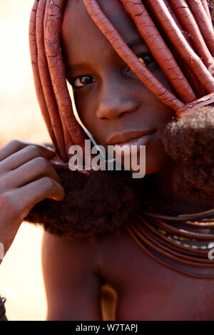 Ritratto di donna Himba con caratteristica Otjize (un mix di burro di cenere e ocra) che copre i capelli e la pelle, Kaokoland, Namibia. Foto Stock