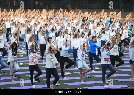 Studenti Cinesi pratica yoga in gruppo per allentare la tensione e l'ansia causata dal prossimo annual college esame di ammissione, noto anche come Gaokao, Foto Stock