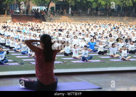 Studenti Cinesi pratica yoga in gruppo per allentare la tensione e l'ansia causata dal prossimo annual college esame di ammissione, noto anche come Gaokao, Foto Stock