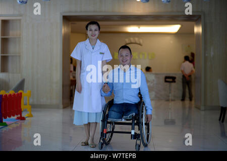 Uomo cinese dai Guohong, che aveva le sue gambe amputate a causa di lesioni gravi causate da 2008 Wenchuan terremoto, è raffigurato con la moglie su Simiao in Foto Stock