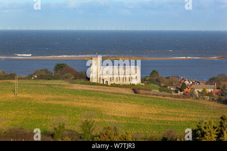 Vista verso la chiesa di San Nicola, con pascoli inondati di palude e violato le scandole di difesa costiera dopo il 6° dicembre east coast picchi di marea in background, Salthouse, Norfolk, Inghilterra, Regno Unito, dicembre 2013. Foto Stock