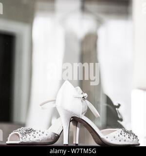 Brides scarpe con la riflessione di vestire in background sul suo giorno di nozze, sposa fotografia prep Foto Stock