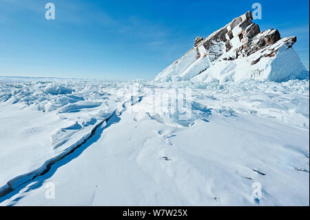 Le grandi crepe nel ghiaccio, con schizzare fuori dal ghiaccio sulla riva del lago Baikal, e la pila di ghiaccio, il lago Baikal, Siberia, Russia, Marzo. Foto Stock