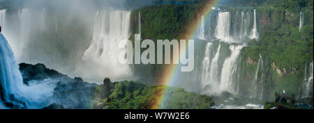 Rainbow su Iguasu Falls, sul fiume Iguasu, Brasile / Argentina confine. Fotografato dal lato Brasiliano delle Cascate. Stato di Paraná, Brasile, Settembre. Foto Stock