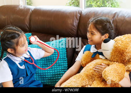 Due bambina sono sorridente e riproduzione medico con stetoscopio. Kid e health care concetto. Foto Stock