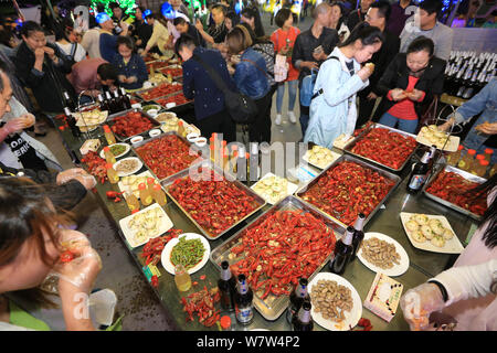 Foodies cinese di mangiare il gambero di fiume durante una festa organizzata da un gourmet plaza per celebrare il suo terzo anniversario in Xiangyang, centrale cinese della provincia di Hubei, 22 Foto Stock