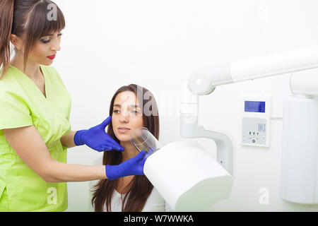 Dentista femmina tenendo a raggi x di una femmina di denti del paziente Foto Stock