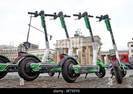 Berlino, Germania. 07 Ago, 2019. E- scooter del pedale sono parcheggiate davanti alla Porta di Brandeburgo. Dopo un incontro con il senatore del traffico, presidente di polizia, distretto di sindaci e rappresentanti di e- pedale fornitori di scooter, non più scooter saranno posizionati in corrispondenza di punti di spicco in città come qui presso la Porta di Brandeburgo. Credito: Wolfgang Kumm/dpa/Alamy Live News Foto Stock