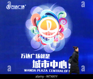 --FILE--A passeggiate a piedi passato un annuncio di Wanda Plaza di Wanda Gruppo in Yichang city, centrale cinese della provincia di Hubei, 8 gennaio 2017. IBM Foto Stock