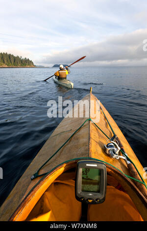 Vista dal kayak come Phil Russell apre la strada ai fondali di pesca lungo lo stretto di Juan De Fuca, Washington, USA, Agosto 2014. Modello rilasciato. Foto Stock