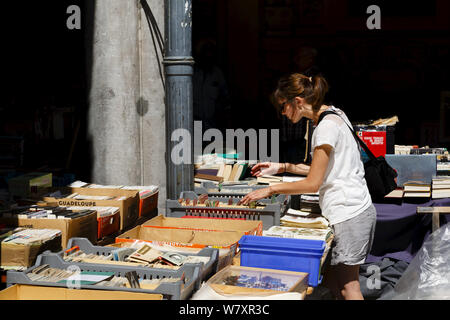 Lille, Francia - 20 luglio, 2013. Una donna accede a un libro in stallo La Vieille Bourse de Lille, la storica ex stock exchange nel centro di Lill Foto Stock