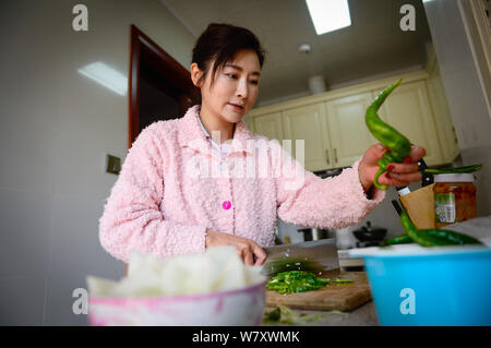 Il 50-anno-vecchio donna cinese Xu Min, dubbed come 'magical bellezza', si prepara per il pasto a casa nella città di Kunming, a sud-ovest della Cina di provincia di Yunnan, 19 Februar Foto Stock