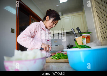 Il 50-anno-vecchio donna cinese Xu Min, dubbed come 'magical bellezza', si prepara per il pasto a casa nella città di Kunming, a sud-ovest della Cina di provincia di Yunnan, 19 Februar Foto Stock