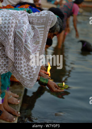 Persone immissione lanterne sul fiume, un offerta per il Gange durante il festival religioso. Varanasi, Uttah Pradesh, India, marzo 2014. Foto Stock