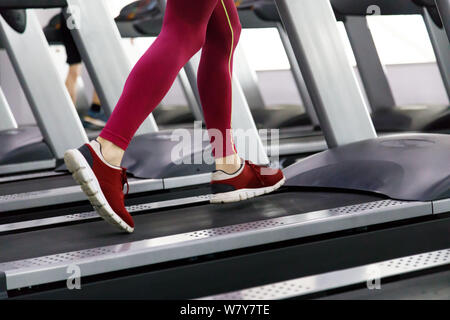 Close up dei maschi di gambe in esecuzione sul tapis roulant in palestra Foto Stock