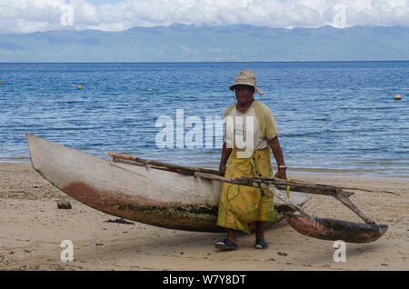 Pescatore con outrigger canoe da pesca. Isola Kioa, Figi, Sud Pacifico, luglio 2014. Foto Stock